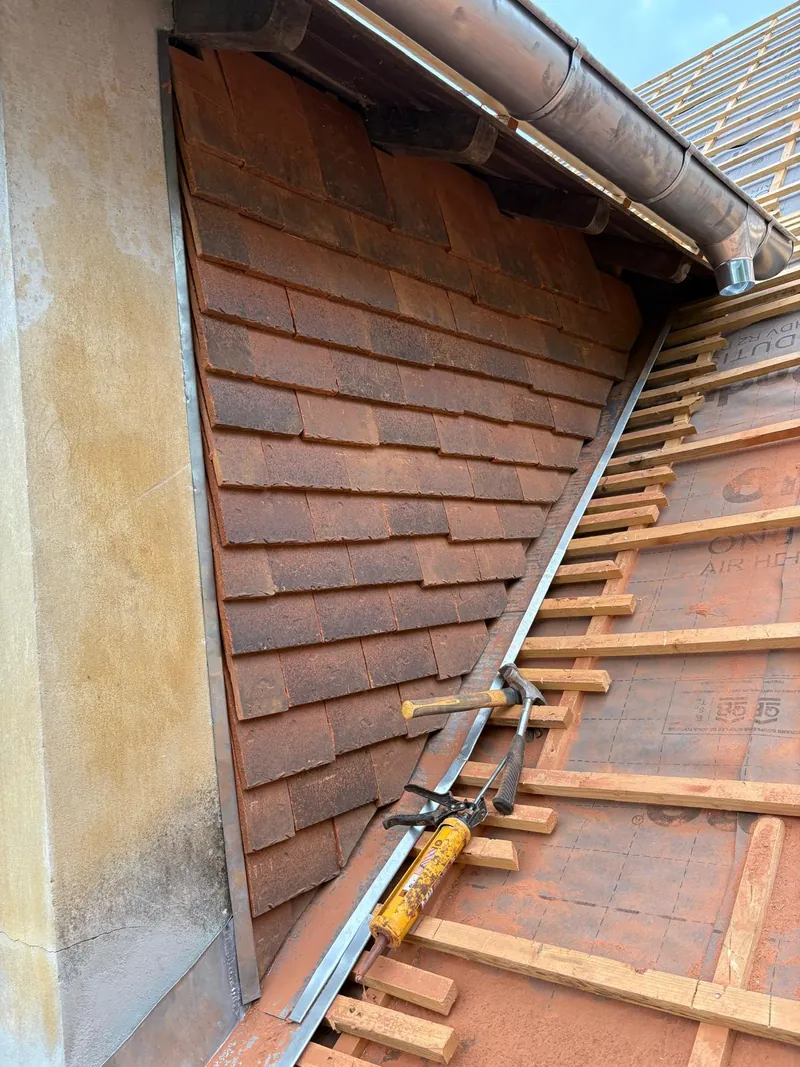 Inspection détaillée d’un raccord toiture/mur, point sensible fréquent en cas de fuite